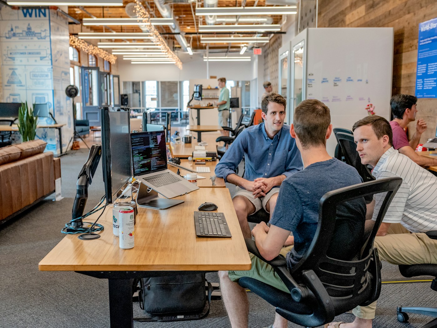 Web development team collaborating at a desk with code open on a laptop